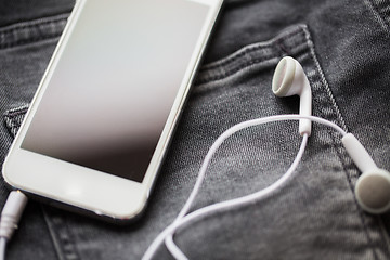 Image showing smartphone and earphones on denim or jeans pocket