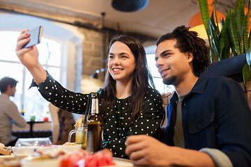 Image showing happy couple taking selfie at cafe or bar