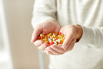 Image showing close up of senior man hands holding pills