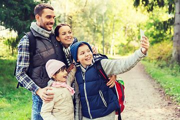 Image showing family with backpacks taking selfie by smartphone