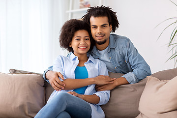 Image showing happy couple sitting on sofa and hugging at home