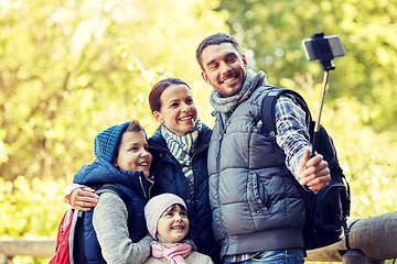 Image showing happy family with smartphone selfie stick in woods