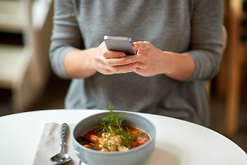 Image showing woman with smartphone and bowl of soup at cafe