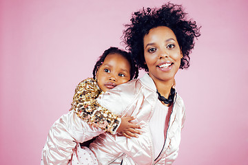 Image showing young pretty african-american mother with little cute daughter hugging, happy smiling on pink background, lifestyle modern people concept 