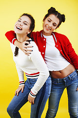 Image showing lifestyle people concept: two pretty young school teenage girls having fun happy smiling on yellow background