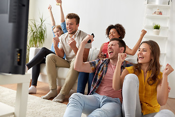 Image showing happy friends with remote watching tv at home