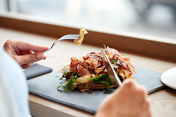 Image showing woman eating prosciutto ham salad at restaurant