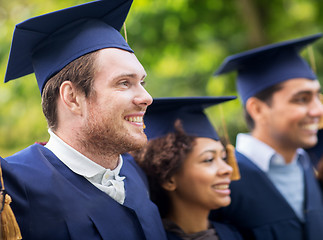 Image showing happy students or bachelors in mortar boards