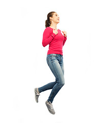 Image showing smiling young woman jumping in air