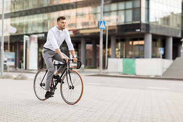 Image showing man with headphones riding bicycle on city street