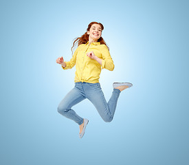 Image showing smiling young woman jumping in air