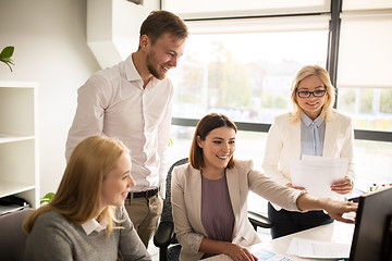 Image showing happy creative team with computer in office