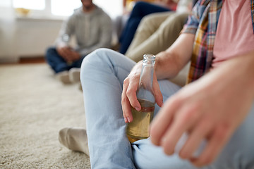 Image showing close up of man with beer bottle and friends