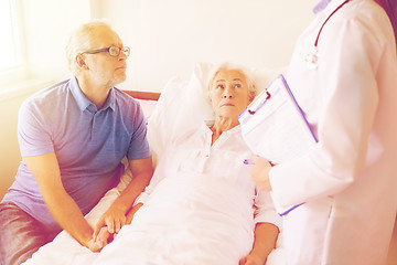 Image showing senior woman and doctor with clipboard at hospital