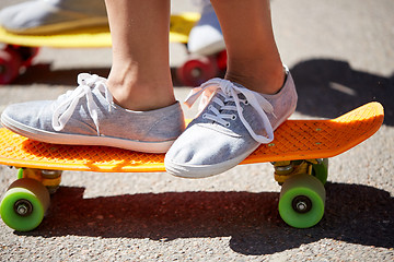 Image showing close up of feet riding skateboards on city street