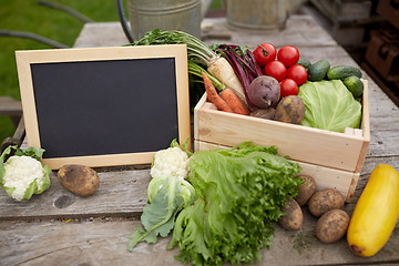 Image showing close up of vegetables with chalkboard on farm