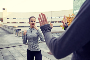 Image showing woman with trainer working out self defense strike