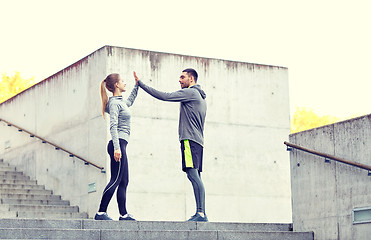 Image showing happy couple giving high five outdoors