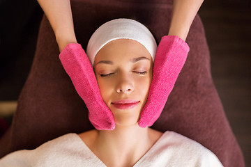 Image showing woman having face massage with terry gloves at spa