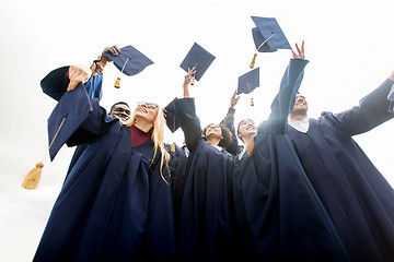 Image showing happy students throwing mortar boards up