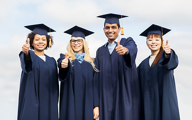 Image showing happy students or bachelors showing thumbs up