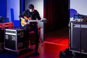 Image showing Roadie tuning a guitar for the guitarist