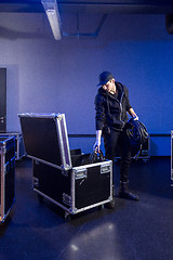 Image showing Roadie picking some cables out of a flightcase