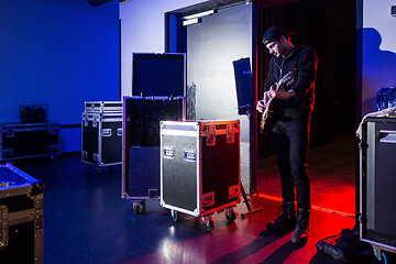 Image showing Roadie playing guitar backstage