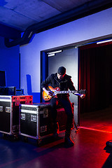 Image showing Roadie tuning a guitar for the guitarist