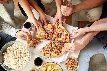 Image showing close up of people taking pizza slices at home