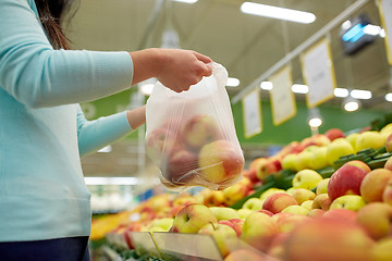 Image showing woman with bag buying apples at grocery store