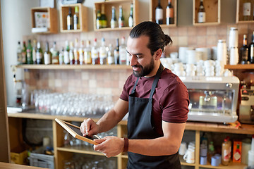 Image showing happy man or waiter with chalkboard banner at bar