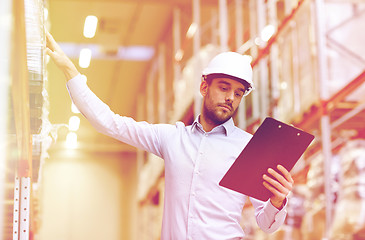 Image showing happy businessman with clipboard at warehouse