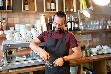 Image showing barista with holder and tamper making at coffee