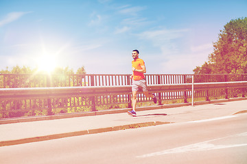 Image showing smiling young man running at summer seaside