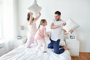 Image showing happy family having pillow fight in bed at home