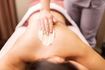 Image showing woman having back massage with cream at spa