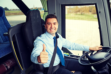 Image showing happy driver driving bus and snowing thumbs up