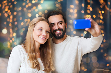 Image showing happy couple with smartphone taking selfie