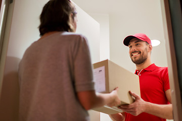 Image showing happy delivery man giving parcel box to customer