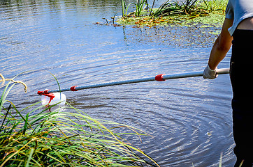 Image showing Take samples of water for laboratory testing. The concept - analysis of water purity, environment, ecology.