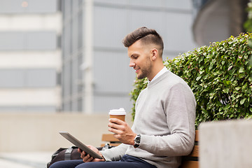 Image showing man with tablet pc and coffee on city street bench