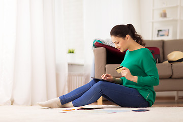 Image showing woman with tablet pc and credit card at home