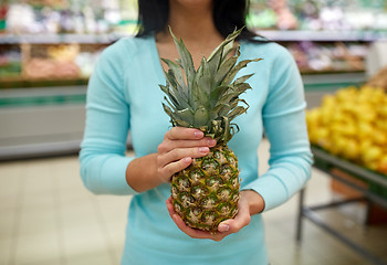 Image showing woman with pineapple at grocery store