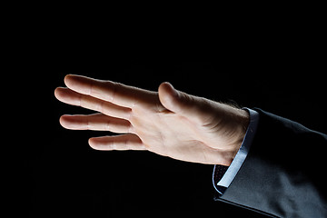 Image showing close up of businessman hand over black background