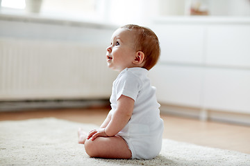 Image showing happy baby boy or girl sitting on floor at home