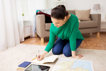 Image showing woman with notebook and travel map at home