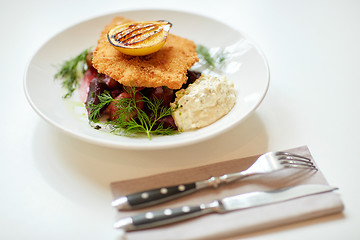 Image showing close up of fish salad with roasted lemon on plate