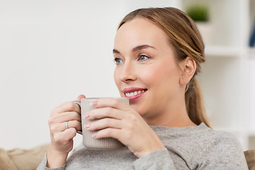 Image showing happy woman with cup or mug drinking at home