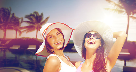 Image showing smiling young women in hats on beach